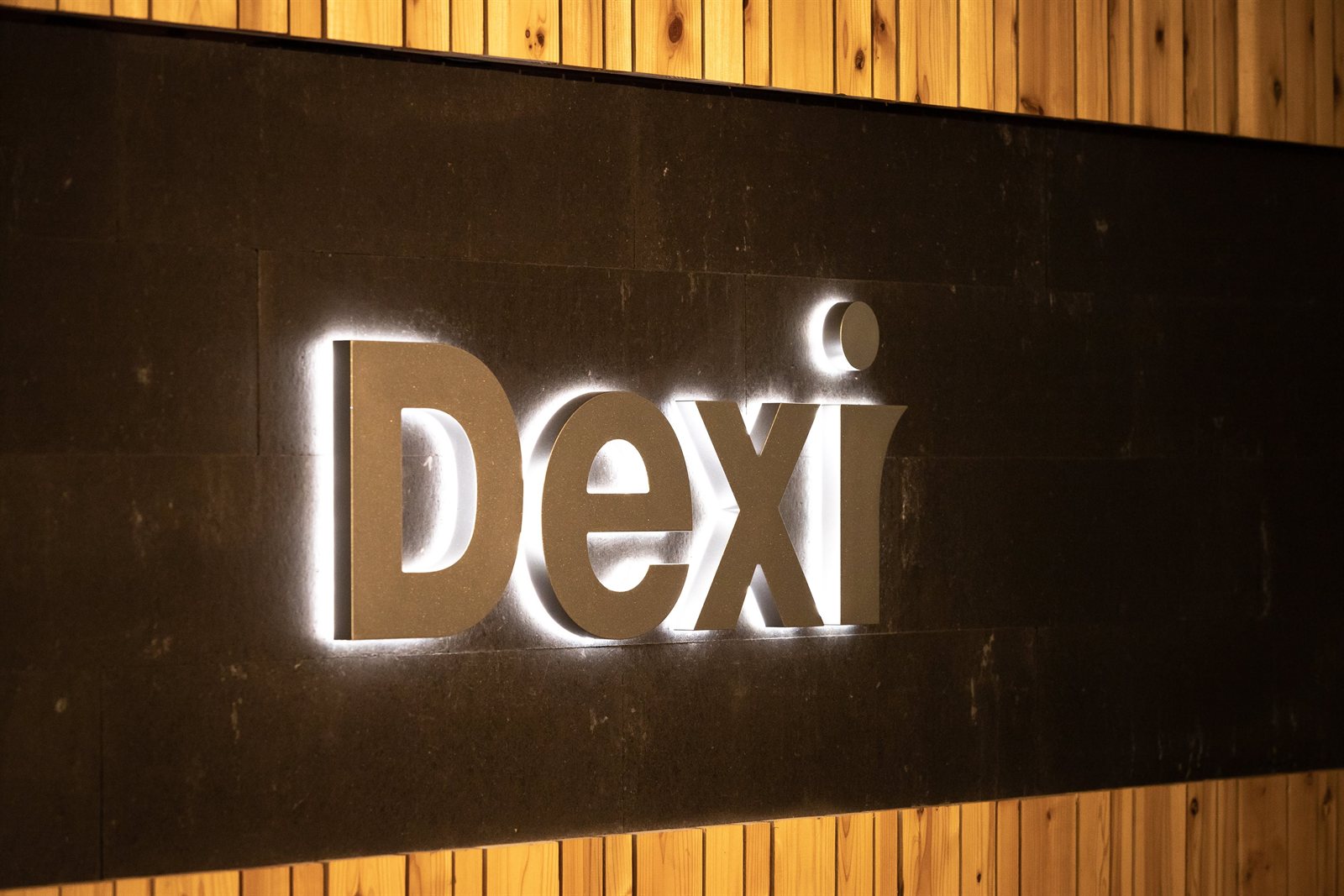 オフィス「Dexi」ロゴの根元発光サイン(アクリル削り出し・木目壁×黒パネル背景・DELIGHT製)