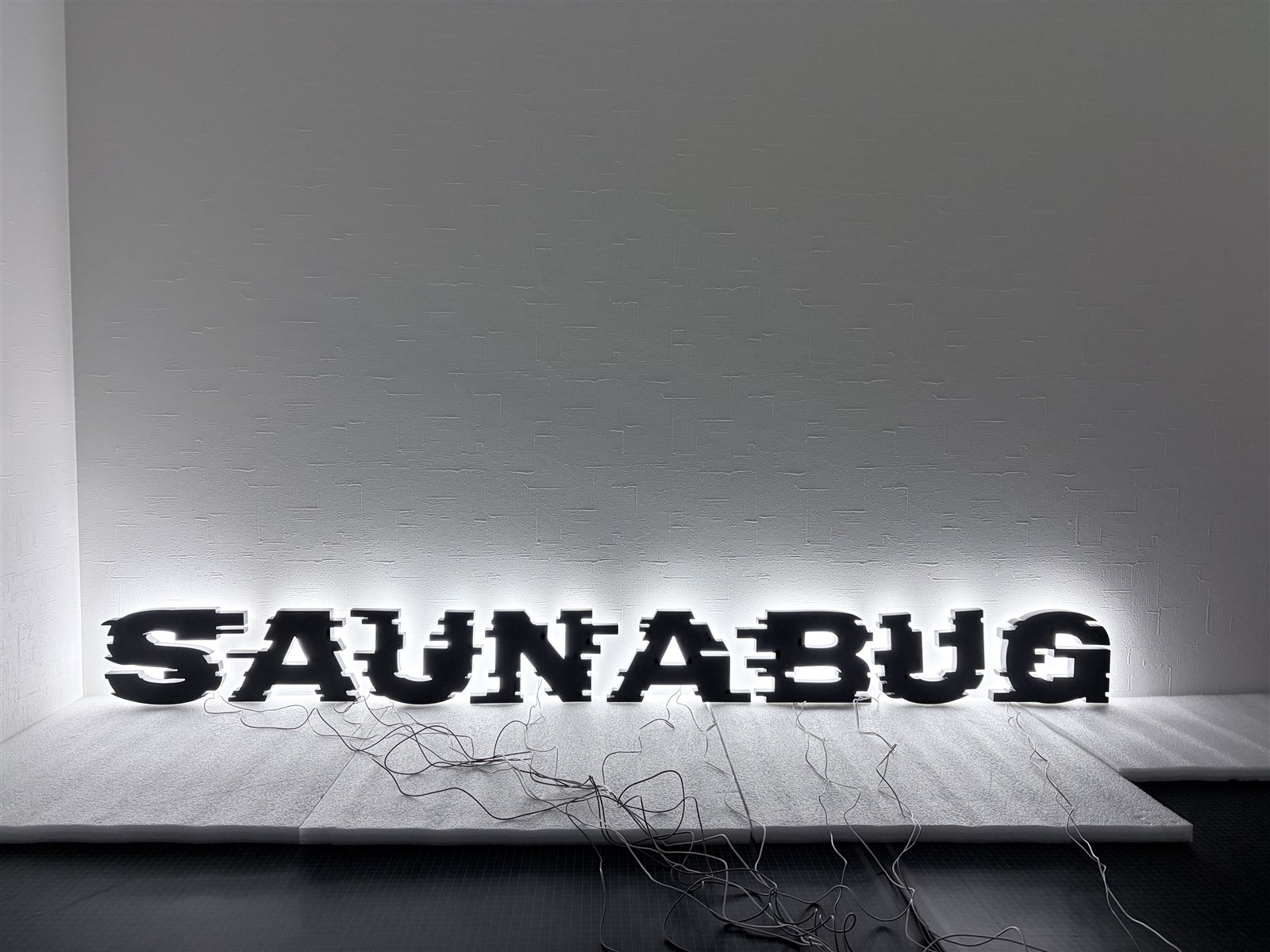 1文字ずつ独立したチャンネル文字の発光テスト検品の様子 根元発光LEDサイン SAUNA BUG様