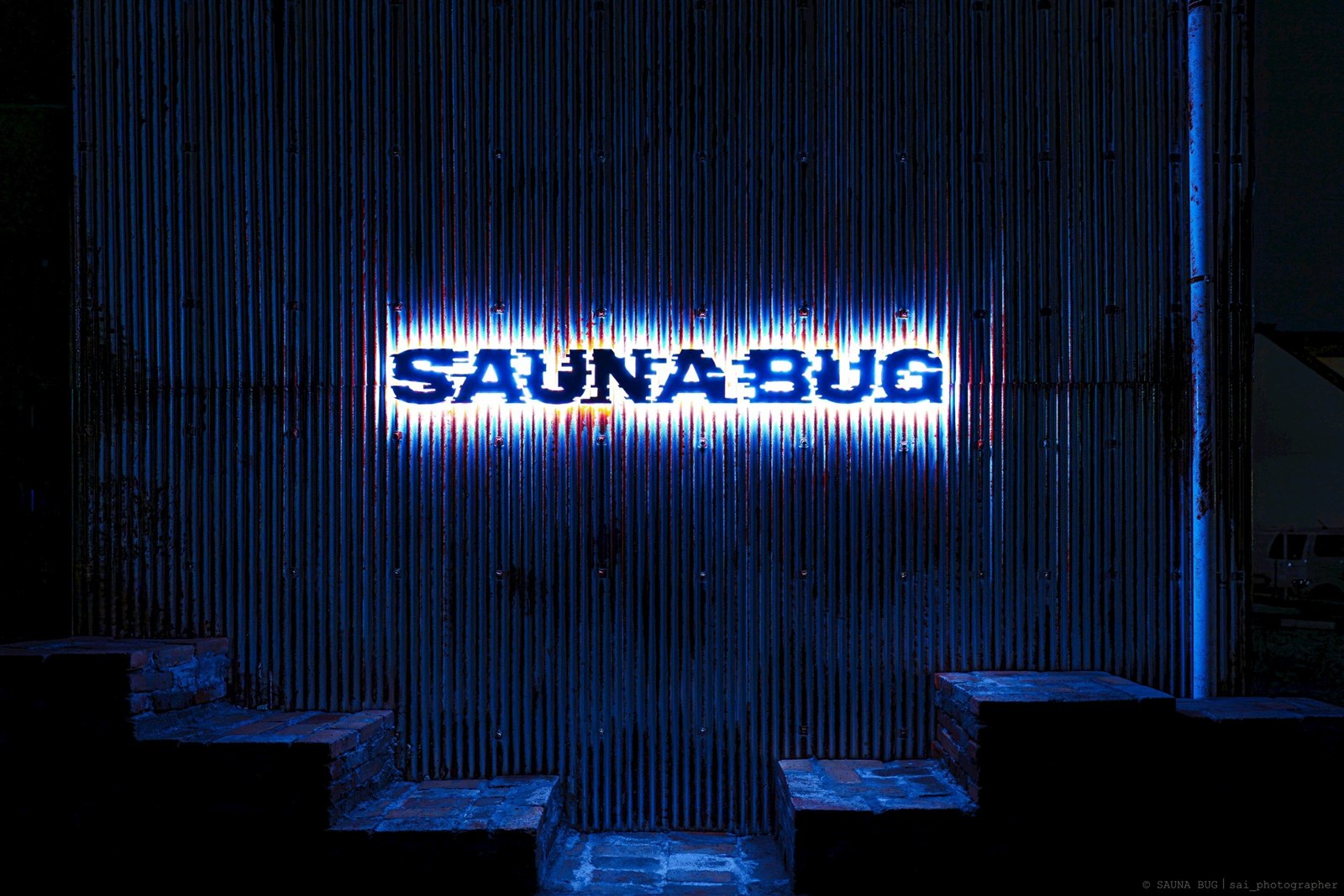 壁面に取り付けたチャンネル文字の夜間点灯 根元発光LEDサインの施工例 SAUNA BUG様