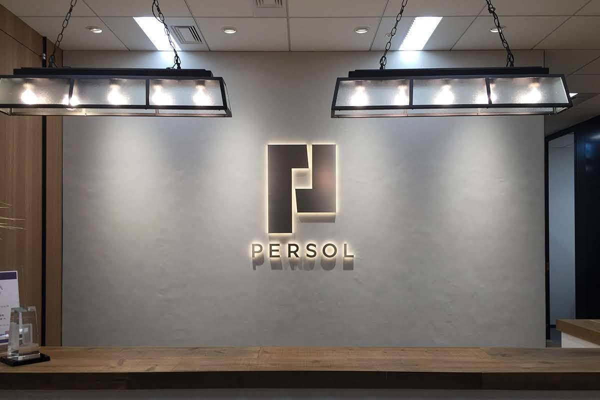 オフィスエントランスの壁面に設置した側面発光チャンネル文字(PERSOL ロゴ、根元発光の効果で壁に光が反射)
