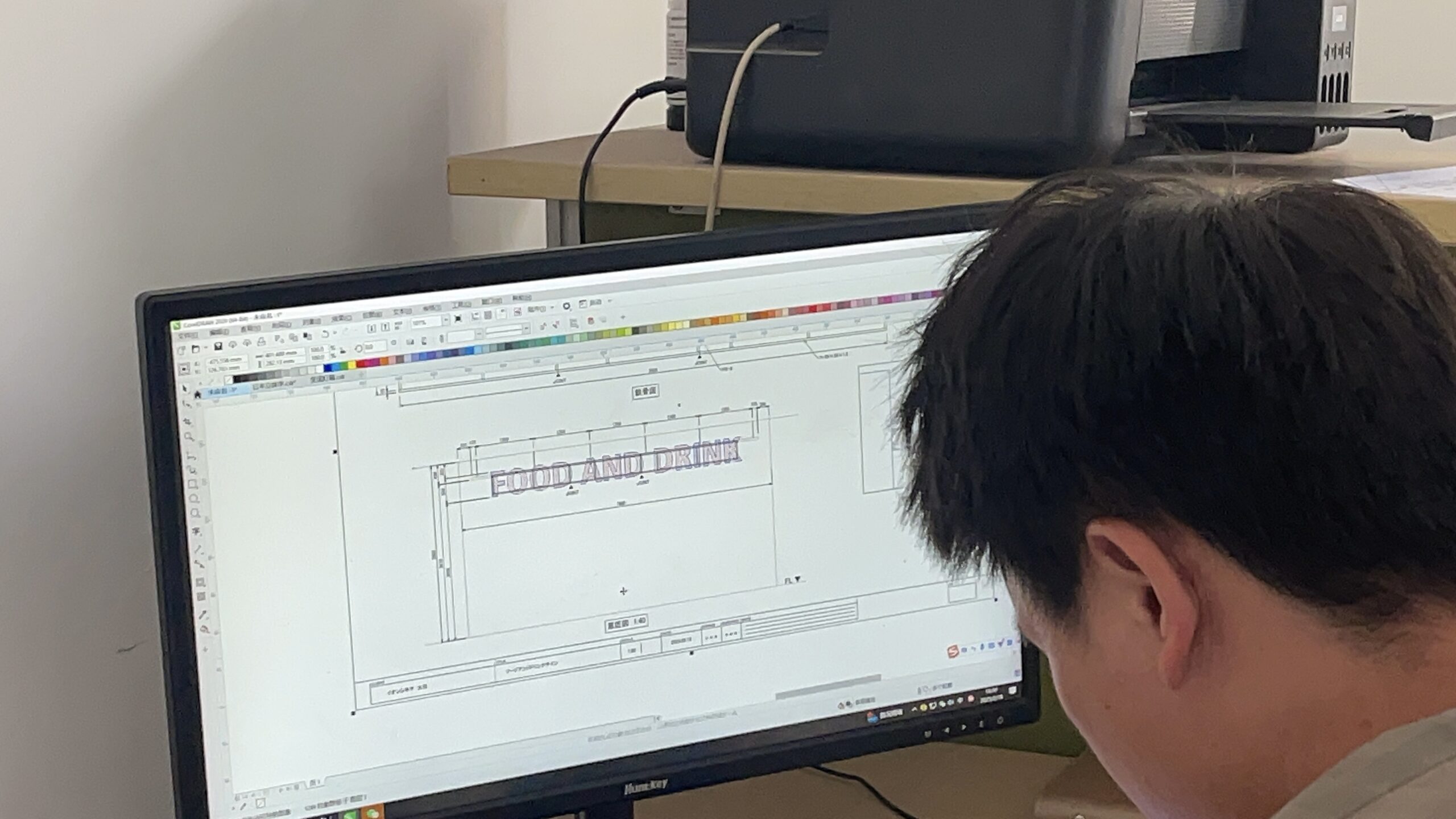 看板のデザインデータを製作用図面に起こすスタッフの作業画面