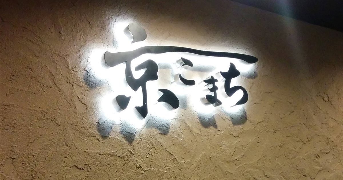 夜の壁に文字のシルエットが浮かぶ背面発光サイン