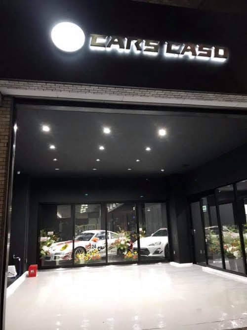 暗い壁に設置したLEDサインの夜間点灯例 白く光る文字 CARS CASO様