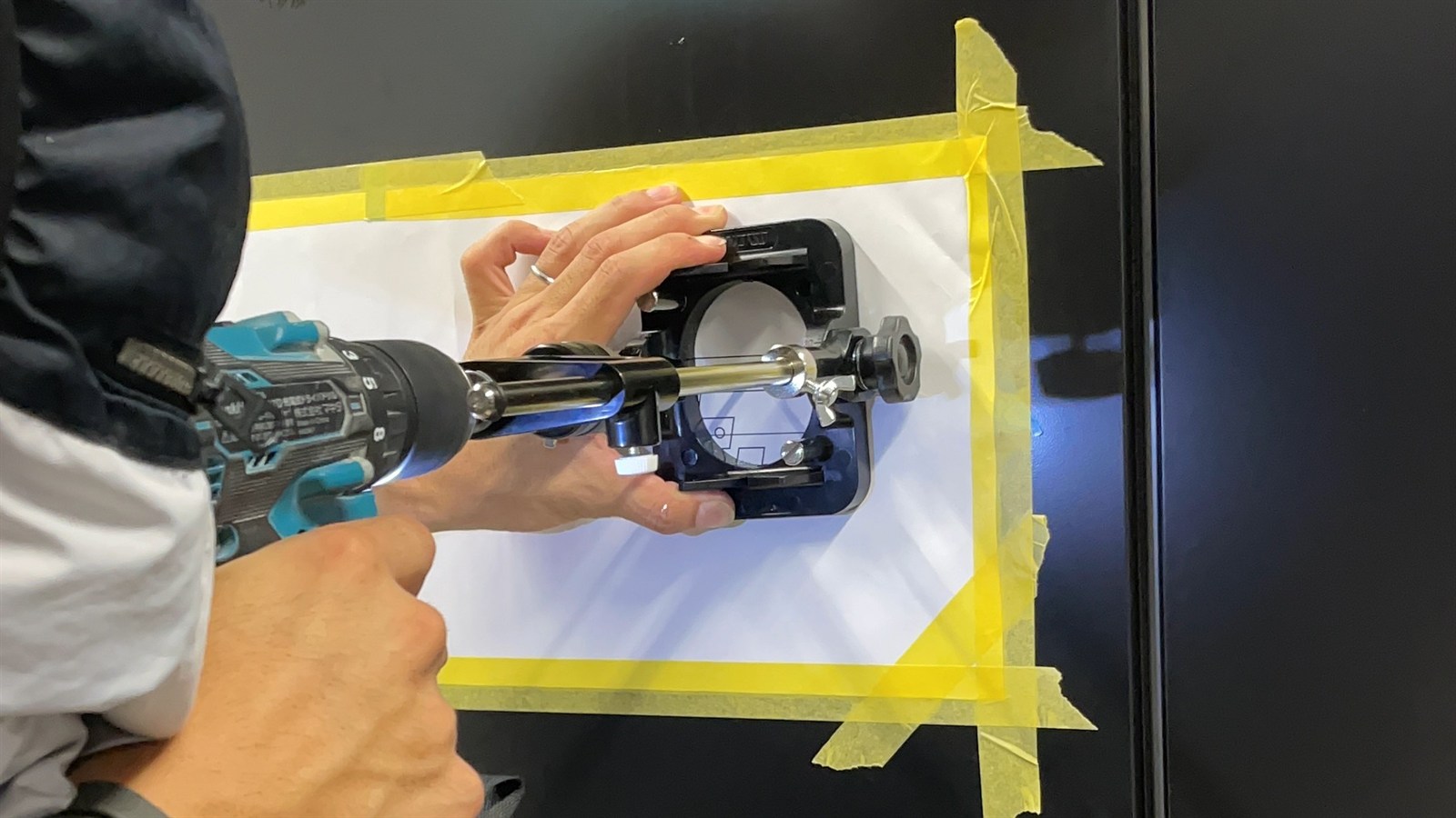 LEDサイン取付の手順2 型紙に合わせてガイド治具とドリルで配線穴を開ける様子