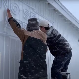 雪の中で店舗外壁にネオンサインを取り付ける現場の様子（FR2羊蹄様）