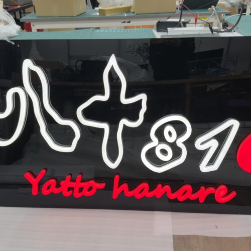 工房で製作中の大型ネオンサインパネル 白と赤のロゴ（八+810 Yatto hanare様）