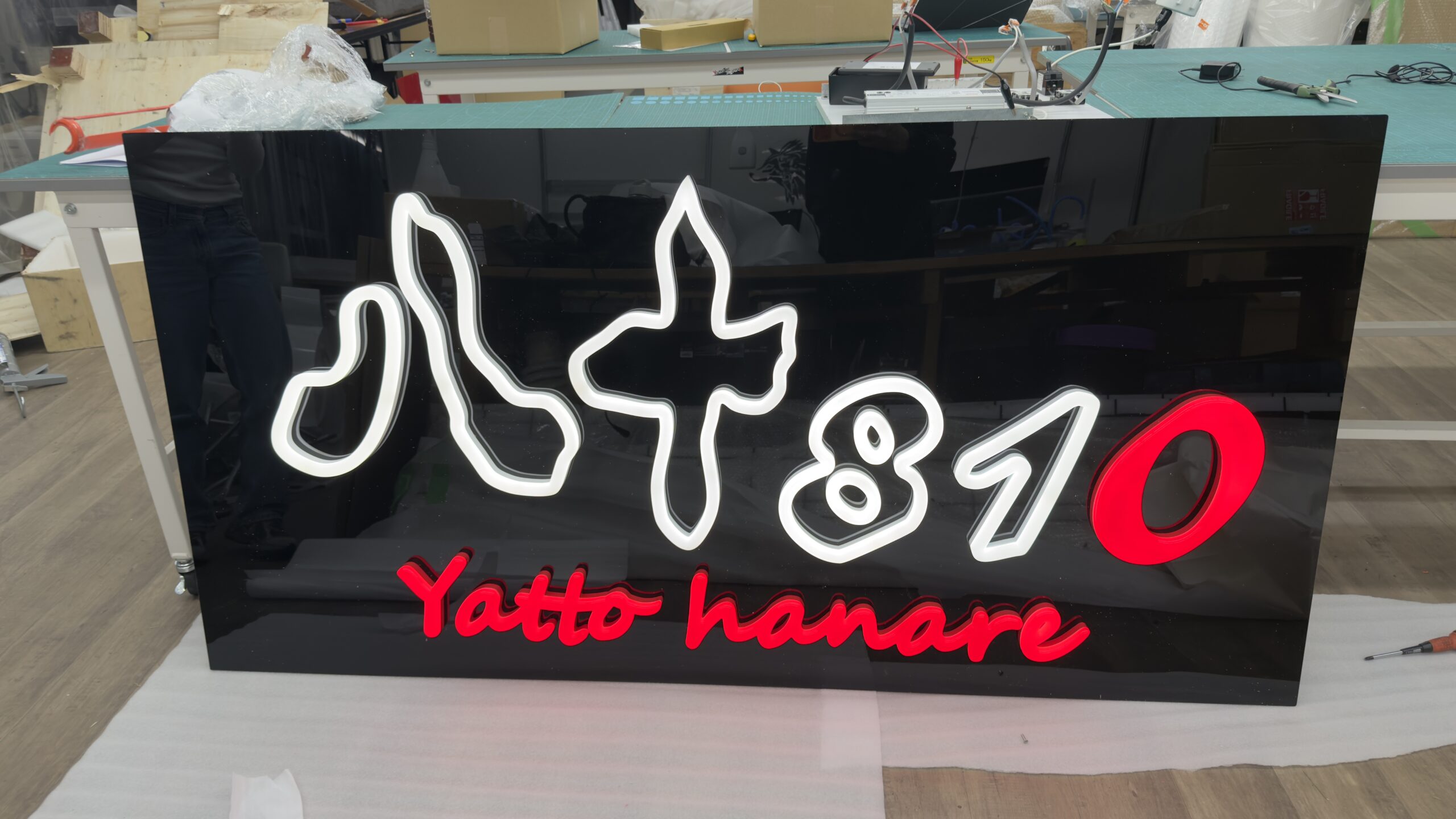 工房で製作中の大型ネオンサインパネル 白と赤のロゴ（八+810 Yatto hanare様）