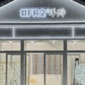 雪夜のアパレル店舗の外観 白いLEDネオンサインで建物の輪郭とロゴを装飾(FR2羊蹄様)