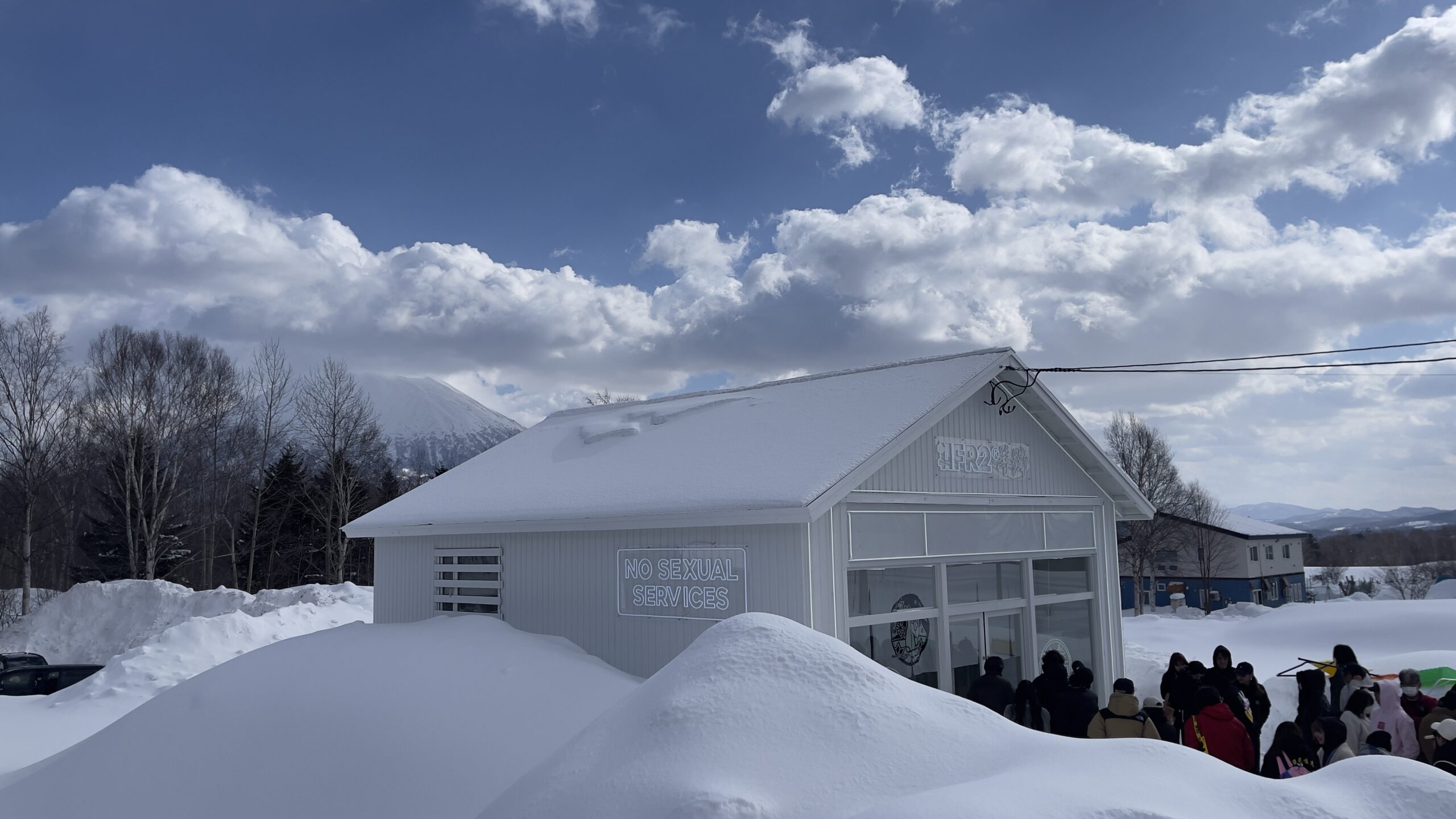 雪景色の街並みの中の店舗外観と屋外ネオンサイン（FR2羊蹄様）
