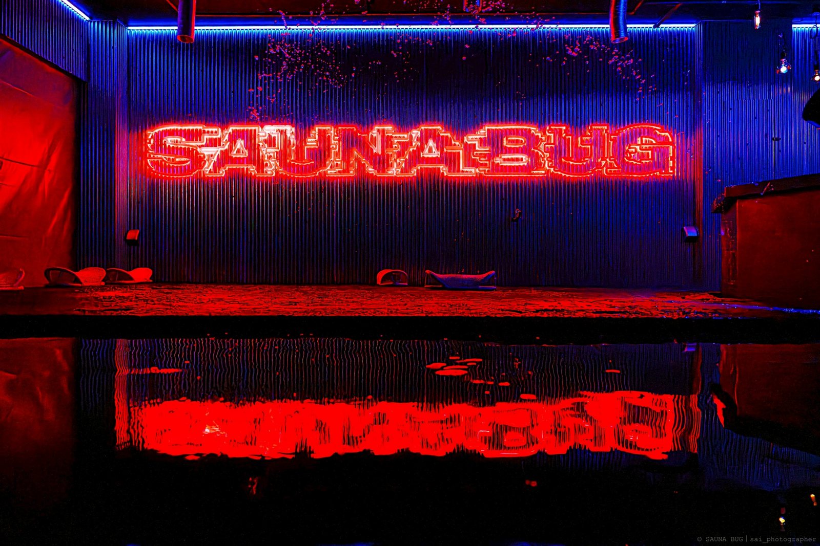 SAUNA BUG館内に設置されたLEDネオンサインの完成写真 赤い光が水面に反射